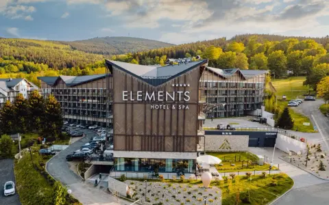 Nowoczesny hotel przy stoku narciarskim w Polsce, Elements Hotel & Spa, otoczony zielenią i górami. Idealne miejsce na zimowy wypoczynek.
