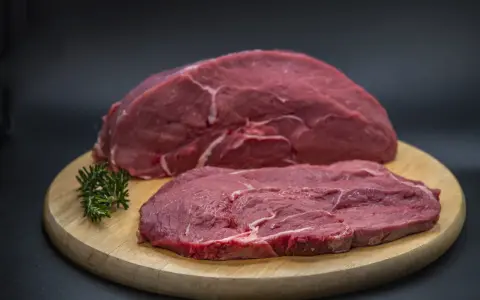Dos filetes de ternera cruda, uno más grueso y otro más fino, sobre una tabla de madera. ¿Qué filetes de ternera son más tiernos?