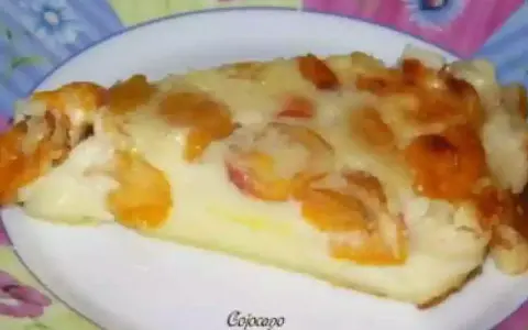 Tranche de clafoutis aux mirabelles alsacienne, dorée et gourmande, sur une assiette décorée.
