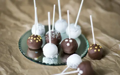 Läckra cakepops med choklad och vit glasyr, dekorerade med stjärnor och snöflingor. Ett enkelt cakepops recept att prova!