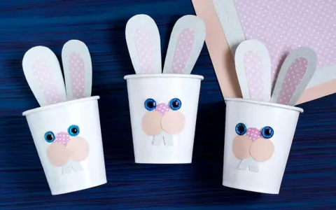 Drei süße Osterhasen-Becher, perfekt für Ostern basteln mit Kleinkindern. Bunte Ohren und lustige Gesichter machen sie zum Hingucker.