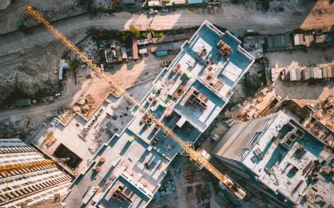 Aerial view of a construction site, showcasing the efficiency of drones in construction by providing an overhead perspective of building progress and material placement.