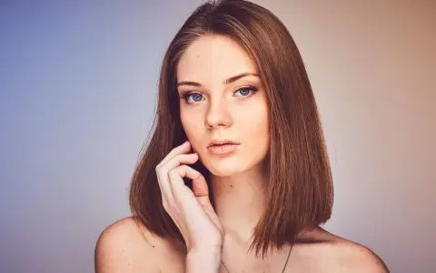 Młoda kobieta z niebieskimi oczami i brązowymi włosami, prezentująca naturalny wygląd dzięki dobremu podkładowi kryjącemu bez efektu maski.
