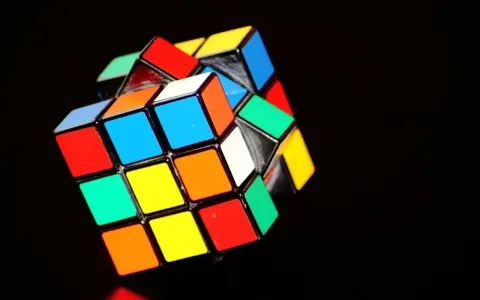 En färgglad rubiks kub 3x3 ligger på en mörk bakgrund.