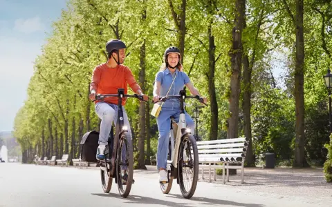 Para jadąca na rowerach trekkingowych w parku. Idealne na wycieczki, nie są to rowery górskie.