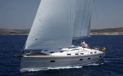 Die **Segelyacht Andromeda** gleitet majestätisch über das tiefblaue Meer, zwei Segel sind gesetzt, zwei Männer am Steuer.
