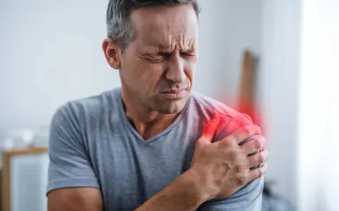 Mann mit schmerzender Schulter, die auf ein Impingement-Syndrom hindeutet, möglicherweise verschlimmert durch die Schlafposition.