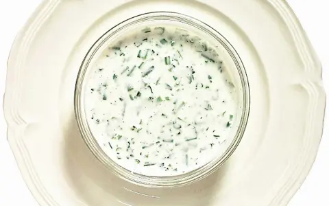 En skål med krämig kall sås till fisk, med finhackade örter som dill och gräslök. Perfekt till sommarens sillbord.