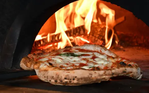 Skąd pochodzi pizza? Od starożytnych placków do globalnego fenomenu.