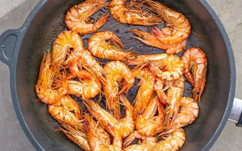 Saftige, tiefgefrorene Garnelen mit Schale werden in einer Pfanne zubereitet. Sie sind perfekt für ein schnelles Abendessen.