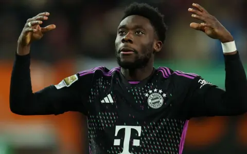 Alphonso Davies, jugador del Bayern de Múnich, celebra con las manos en alto.