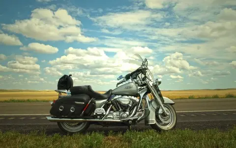 Srebrny motocykl Harley-Davidson na poboczu drogi, gotowy na odkrywanie **tras motocyklowych Czechy**.
