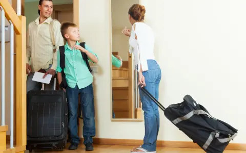 Rodzina w komplecie, z walizkami, gotowa na urlop. Ojciec trzyma dokumenty, syn plecak, a matka walizkę na kółkach. Czas na zasłużony odpoczynek zgodny z kodeksem pracy.