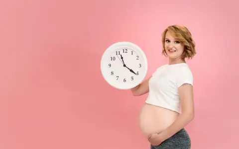 Czekasz na poród? Zegar w rękach ciężarnej sugeruje, jak przyspieszyć poród, choć to tylko symboliczne pytanie.