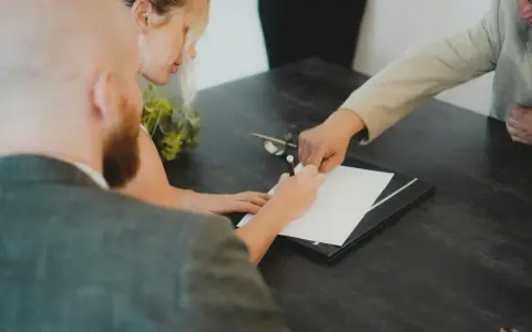 Para z dumą podpisuje dokumenty, finalizując swoją ugoda.