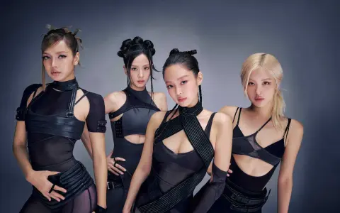 Medlemmar av Blackpink poserar i futuristiska svarta outfits.