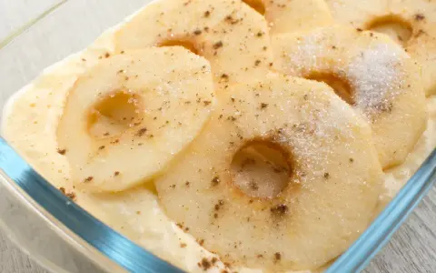 Apfelscheiben in einer cremigen Soße, bestreut mit Zucker und Zimt. Ein leckeres Rezept mit Apfel als Hauptgericht.