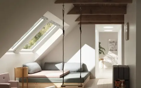 Aménagement d'un grenier lumineux avec balançoire, lit bas et coin jeux. Idées pour comment aménager un grenier en espace cosy.