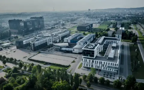 Nowoczesne budynki ULO Gdańsk w otoczeniu zieleni i infrastruktury miejskiej.