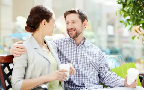 Pareja sonriente compartiendo un café, un ejemplo de comunicación efectiva.