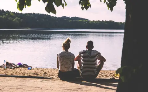 Para, siedząca na plaży, patrzy na jezioro. Czy to idealny partner dla byka?