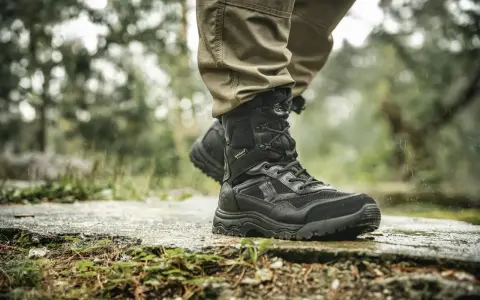 Czarne, wysokie buty na wycieczki w góry, z membraną HydroGuard, gotowe na deszczową pogodę i trudny teren.