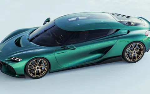 Ein smaragdgrüner Koenigsegg Gemera PS mit goldenen Felgen, der Eleganz und Kraft ausstrahlt.