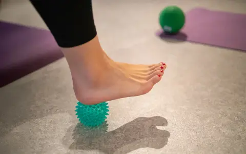 Fußmassage mit Igelball zur Linderung von Fersensporn.