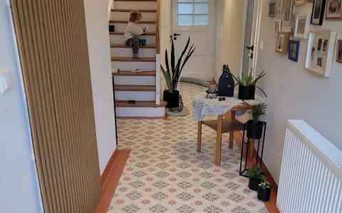 Un enfant sur les escaliers, un sol avec une peinture carrelage aux motifs floraux. La durée de vie de ce revêtement est impressionnante.