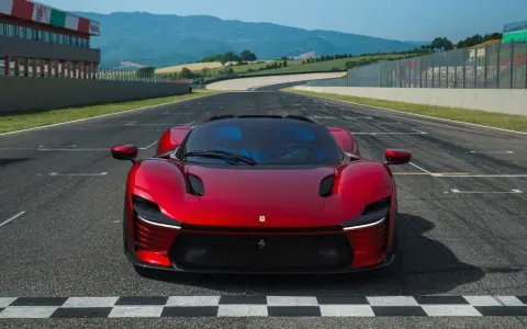 Czerwone Ferrari Daytona SP3 na linii startu toru wyścigowego, gotowe do przekroczenia mety.