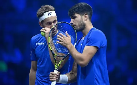 Carlos Alcaraz y Casper Ruud, dos tenistas en un momento de concentración, con raquetas y pelota.