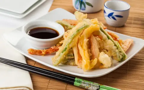 Crujiente tempura de verduras, con zanahoria, calabacín y pimiento, servida con salsa de soja.