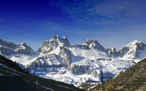 Majestuosas cumbres nevadas en Candanchú, un paisaje de verano que invita a la aventura.