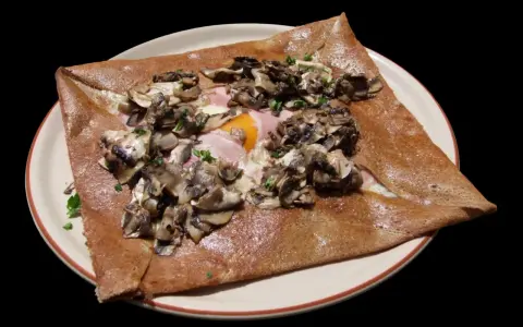 Galette complète garnie de jambon, œuf, champignons et persil. Une recette savoureuse pour un repas rapide.