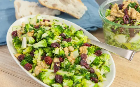 Frischer Brokkolisalat mit Cranberries und Walnüssen. Ein köstliches, **high protein vegetarisch** Gericht, serviert mit Brot.