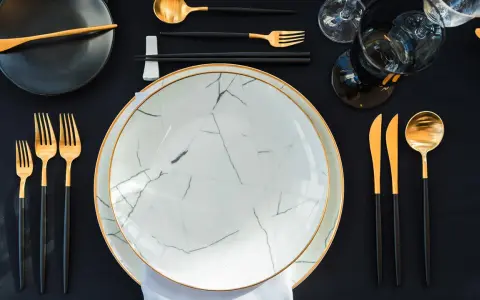 Une table dressée avec élégance, évoquant une ancienne tradition française. Vaisselle moderne aux accents dorés, prête pour un repas raffiné.