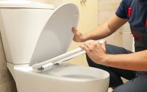 Man installing a toilet with horizontal outlet.