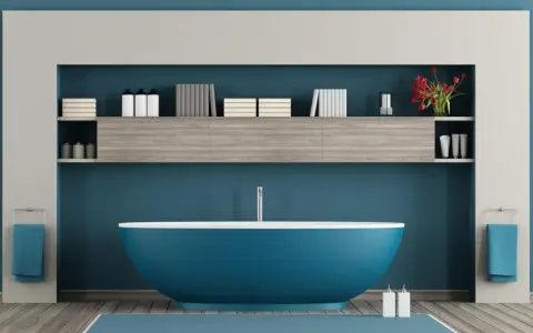 Un moderno bagno azzurro con vasca centrale, mensole piene di libri e flaconi, e due asciugamani blu appesi.