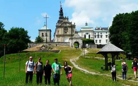 Grupa turystów na tle klasztoru na Świętym Krzyżu, miejscu pełnym łysa góra legend.
