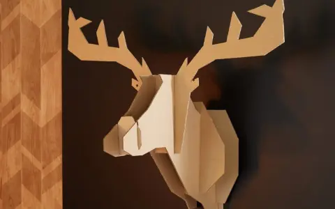 Trophée de cerf stylisé, œuvre de bricolage avec du carton de récupération, accroché sur un mur sombre à côté d'un panneau décoratif en bois.