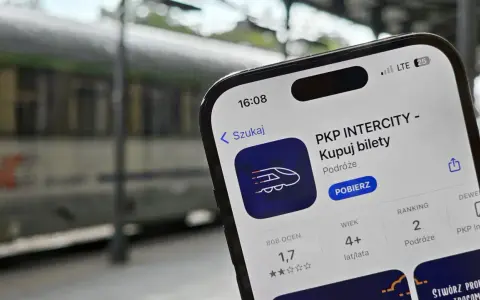 Telefon z aplikacją PKP Intercity na tle pociągu.