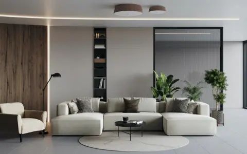 Un ampio divano modulare, perfetto per un soggiorno open space, con poltrona, libreria e piante.