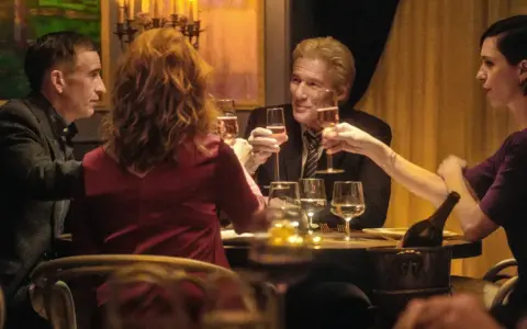 Quattro persone brindano durante una cena elegante, con bicchieri di champagne e un'atmosfera intima.