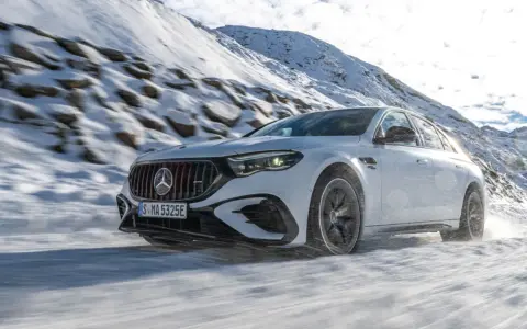 Weißer Mercedes-AMG mit 4MATIC fährt durch verschneite Berglandschaft.