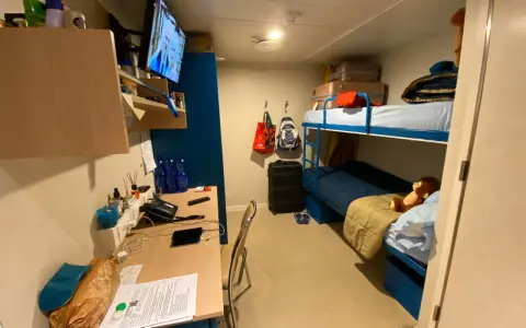 Cosa trovo in cabina Costa Crociere: letti a castello, scrivania con TV, valigie e un peluche.