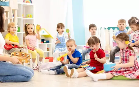 Wesołe zabawy w przedszkolu: dzieci grają na instrumentach, śpiewają i bawią się w rytm muzyki.