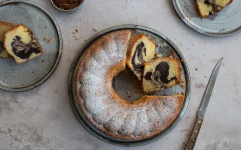 Ein köstlicher Marmorkuchen, frisch gebacken und mit Puderzucker bestäubt. Dieses Marmorkuchen Rezept ist ein Klassiker.
