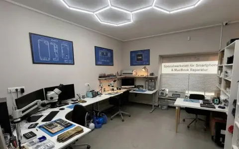 Werkstatt für Smartphone- und MacBook-Reparatur mit Werkzeugen, Mikroskop und technischen Zeichnungen.