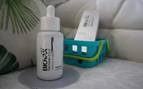 Buteleczka peelingu do skóry głowy L'biotica Bio-Vax Trychologic Advanced Detox stoi na szarej podkładce.