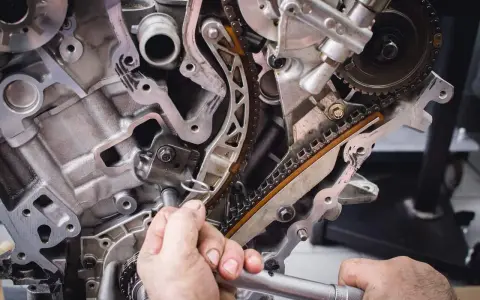 Mechanik pracuje przy rozrządzie silnika. Wymiana poduszki silnika może być konieczna, gdy pojawią się objawy takie jak wibracje.